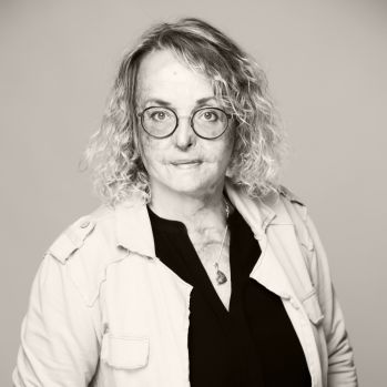 Das Schwarz-Weiß Foto zeigt Dipl. Designerin Anja Pfeiffer-Amankona, die selbstbewusst in die Kamera schaut. Inhaberin und Creative Director.